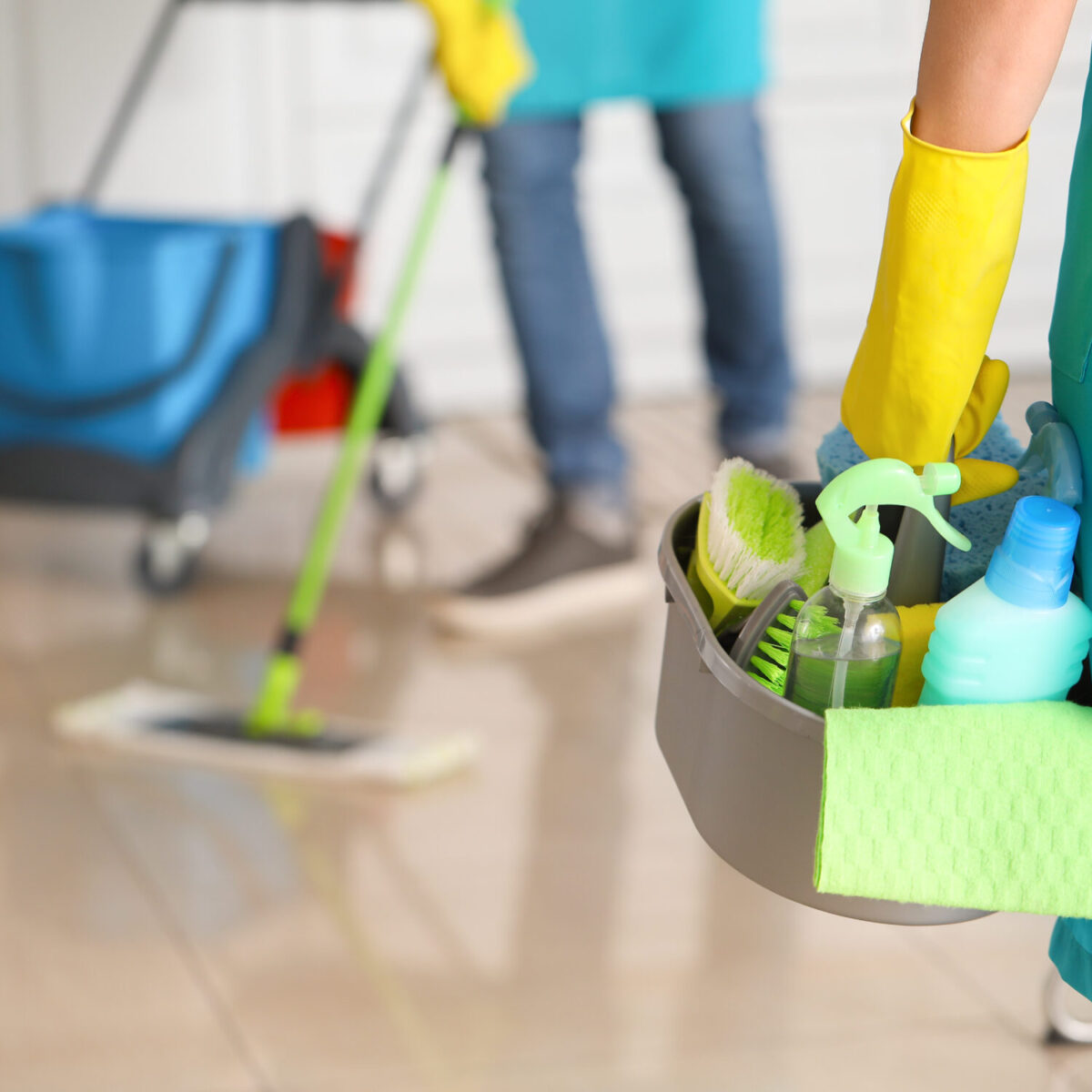 Female janitor with cleaning supplies in kitchen